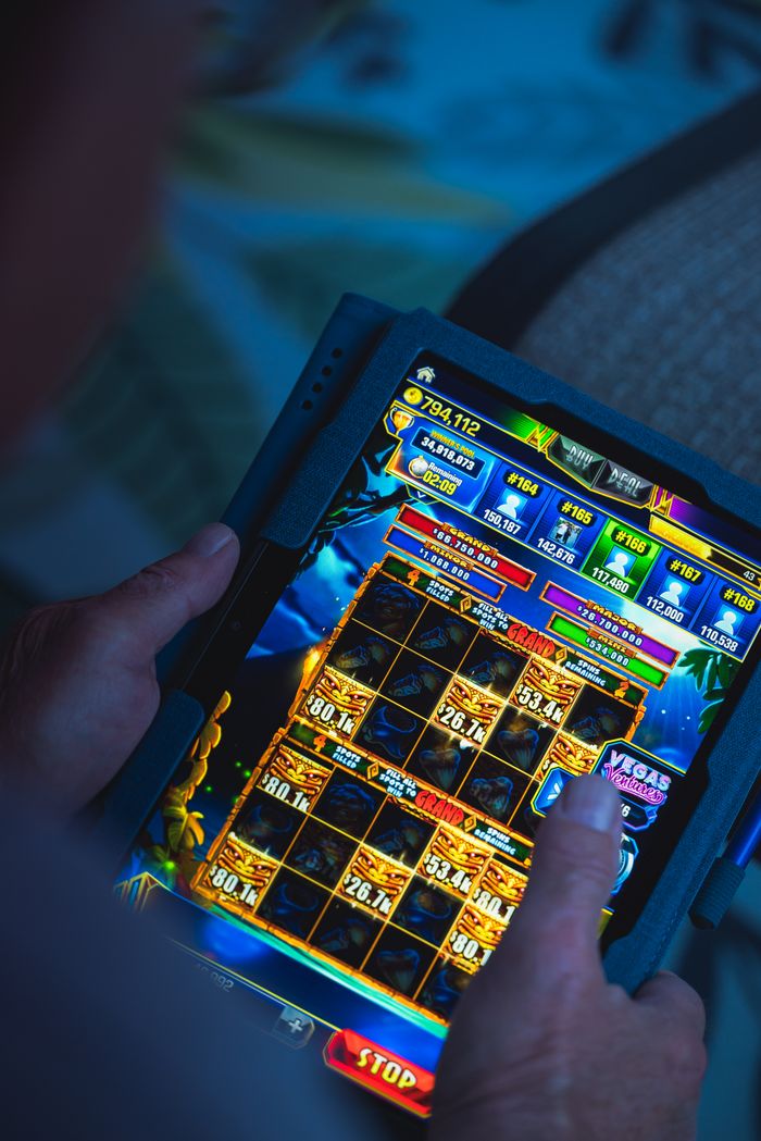 services-01 Person playing a mobile gaming app on a tablet, focused on fun and entertainment.